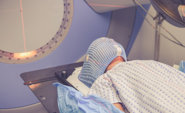Niño con máscara de protección recibe terapia en el acelerador lineal