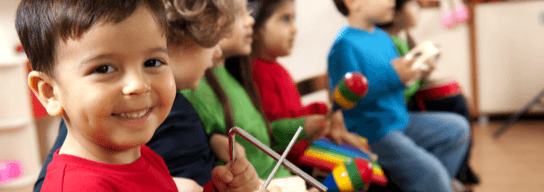 Varios niños, uno de ellos voltea a la cámara y sonríe.