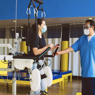 Terapeuta y paciente utilizan el robot para la marcha, Lokomat