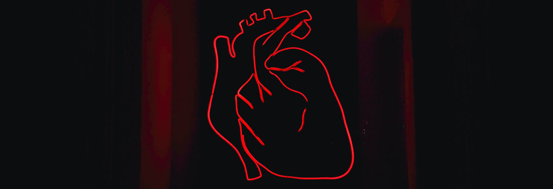 Ilustración del contorno de un corazón, con color rojo, sobre un fondo negro