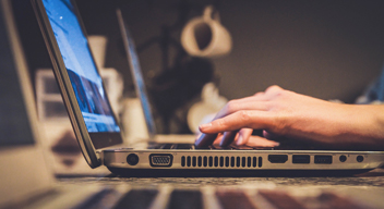 Las manos de una persona están en el teclado de una computadora portátil