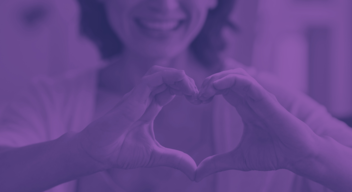 Foto de una mujer haciendo con sus manos la forma de un corazón